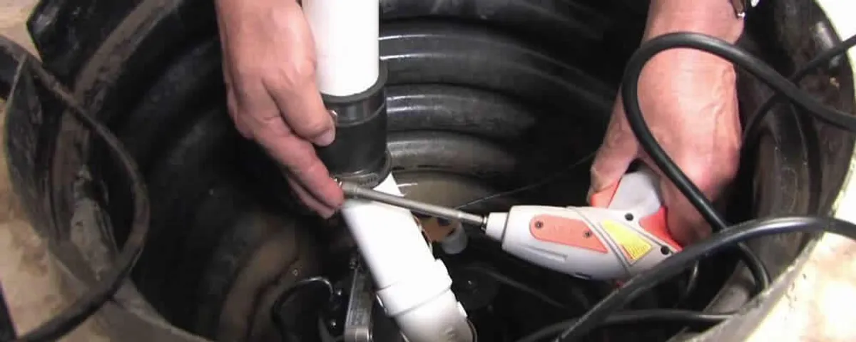 Sump pump installation technician connecting PVC discharge piping in Peoria, IL